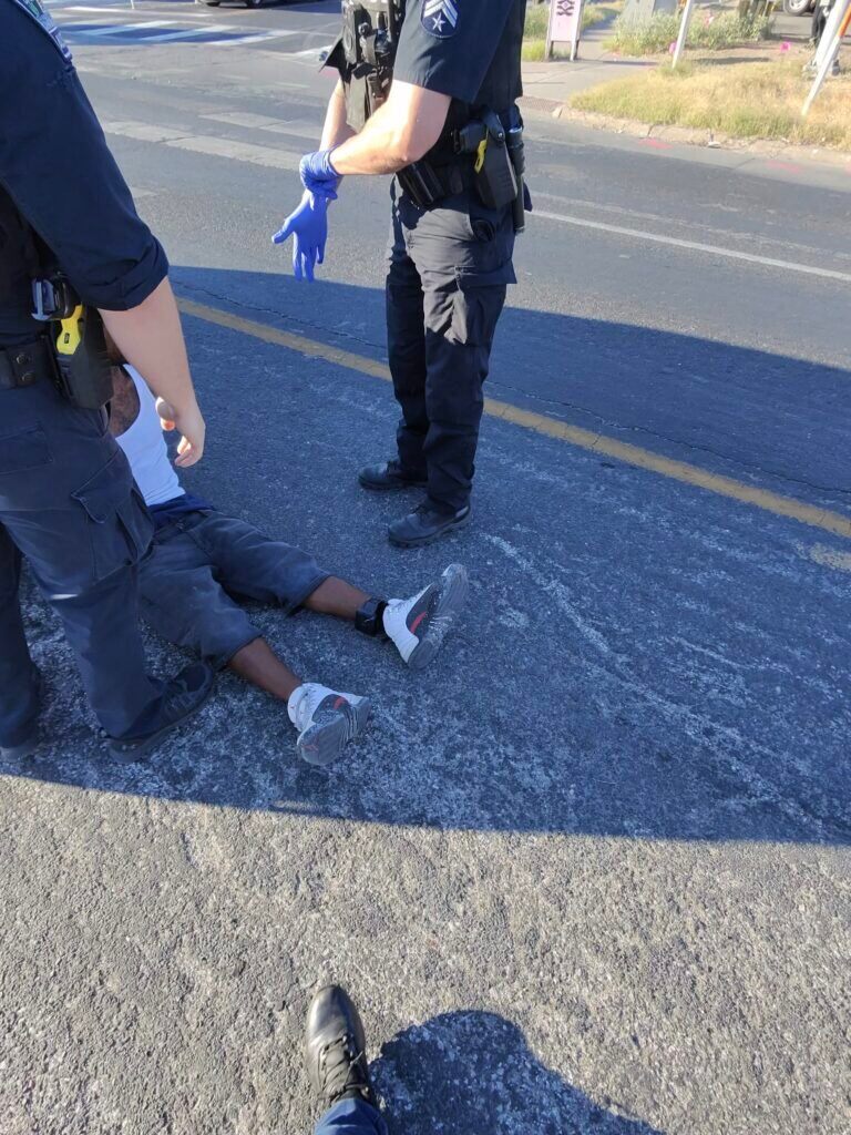 Policiais conduzindo indivíduo em conflito com a justiça